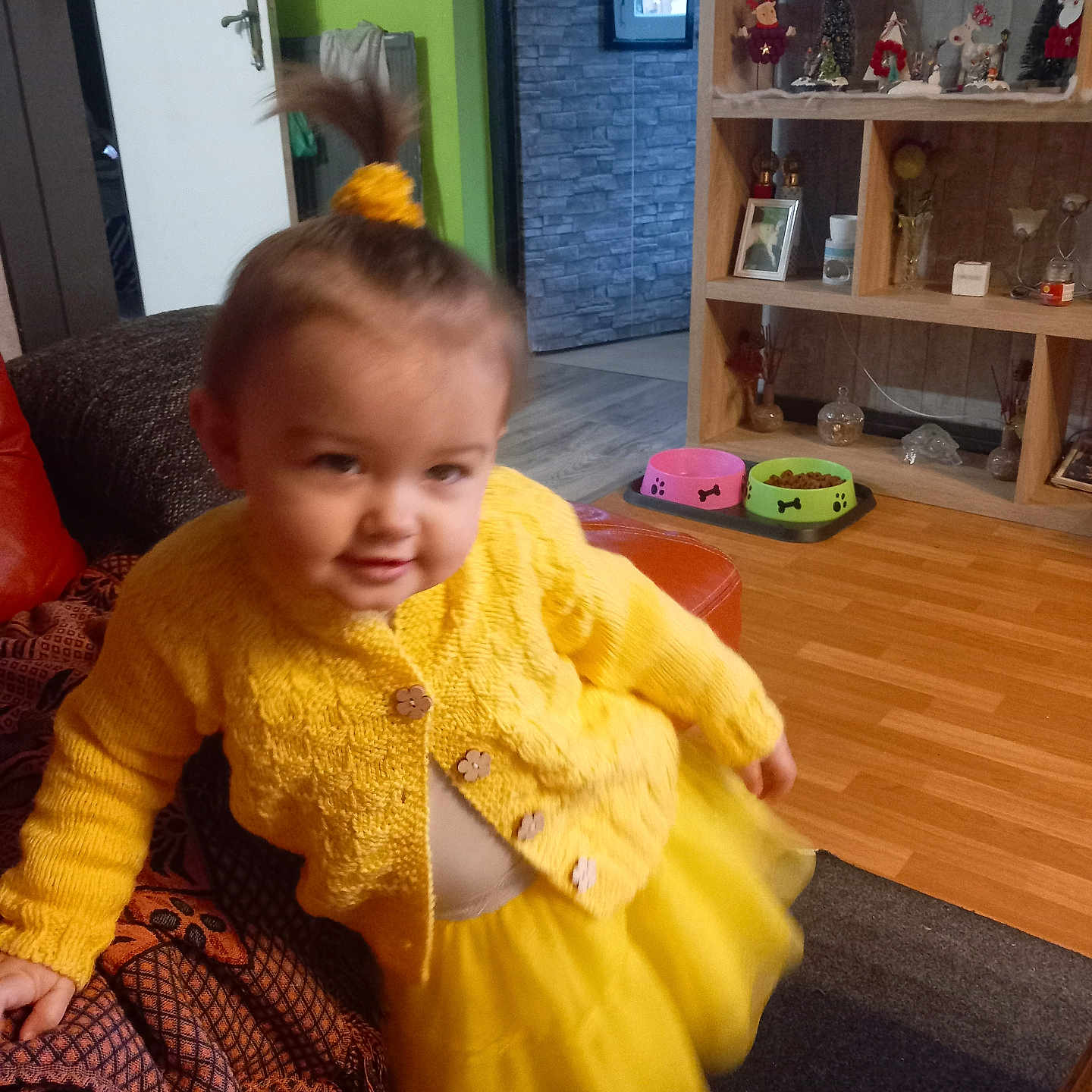 Iris a rejoint le concours — aidez-le/la à gagner de superbes lots ! child, couch, cozy, face, hair_tie, happy, home_decor, indoor, living_room, person, pet_bowls, playful, shelf, skirt, smiling, sweater, toddler, toy, wood_floor, yellow_clothing