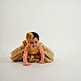 Alexandra is registered to the contest to win money with this photo: baby, child, golden_dress, crawling, headpiece, curly_hair, happy, indoor, white_background, portrait, cute, infant, smiling, hands, floor, dress, fashion, young_child, studio, adorable