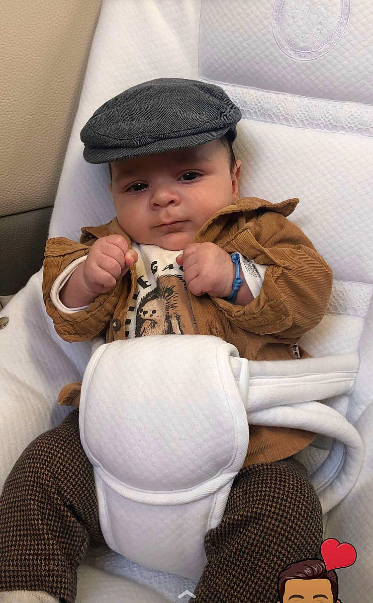 Nolan participe au concours pour gagner de l'argent avec cette photo : baby, baby_products, baby_toddler_clothing, cap, car_seat, child, comfort, dishware, drinkware, fashion_accessory, fur, happy, head, headwear, helmet, pattern, person, porcelain, serveware, sitting