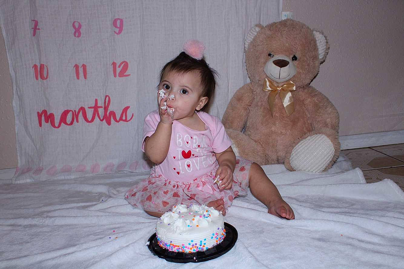 Araya is registered to the contest to win money with this photo: baby, birthday_cake, cake, cake_decorating, cake_decorating_supply, child, dessert, dress, event, flooring, food, fun, happy, icing, lighting, person, pink, sugar_cake, toddler, toy