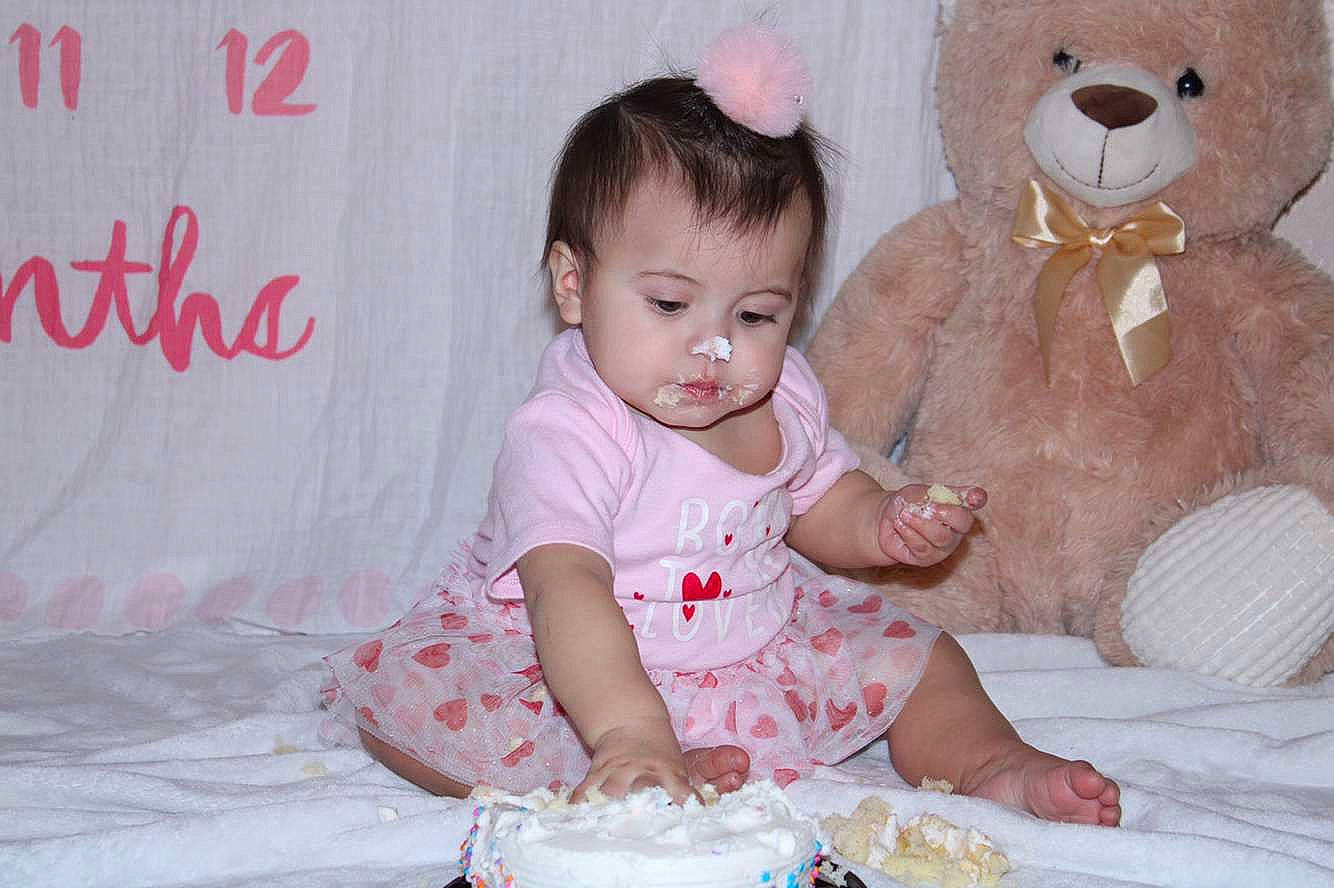 Araya is registered to the contest to win money with this photo: baby, baby_toddler_clothing, beauty, child, dress, event, face, fun, happy, head, person, pink, skin, sleeve, stuffed_toy, sugar_cake, teddy_bear, textile, toddler, toy