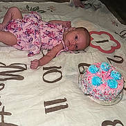 Liana joined the competition — help win amazing prizes! baby, infant, pink_dress, milestone_blanket, birthday_cake, candle, floor, wooden_floor, feet, person, celebration, laying_down, baby_girl, clothing, home, indoors, colorful, decorations, milestone, cute