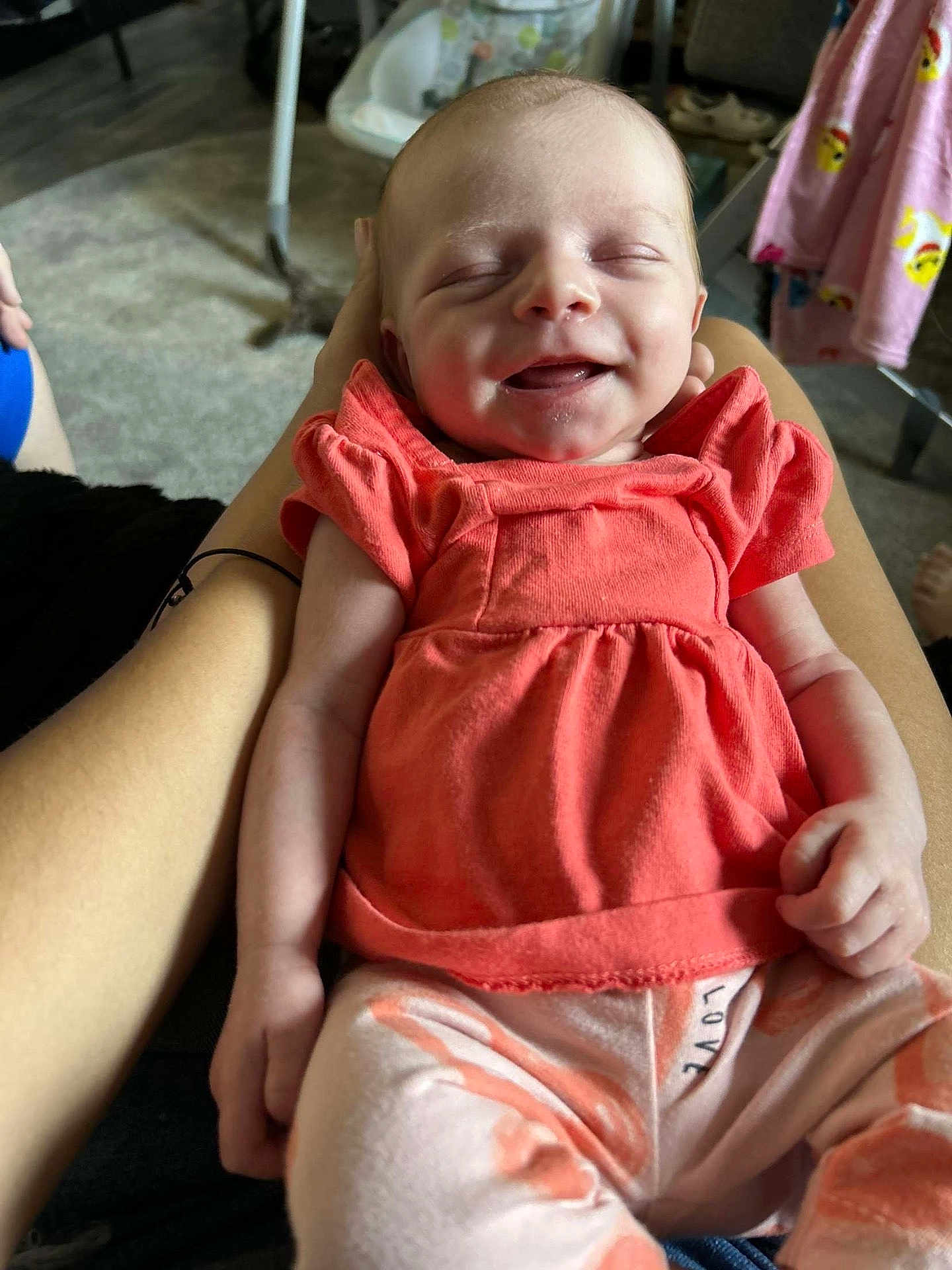 Liana joined the competition — help win amazing prizes! baby, smiling, infant, child, clothing, coral_top, pants, love_print, person, indoor, carpet, legs, hand, relaxed, happy, face, closed_eyes, seated, comfort, cute