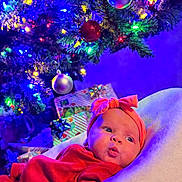 Parker joined the competition — help win amazing prizes! baby, infant, red_clothing, headband, bow, blanket, christmas_tree, christmas_lights, ornaments, presents, holiday, festive, decorations, indoors, soft_texture, cute, portrait, colorful, celebration, cozy