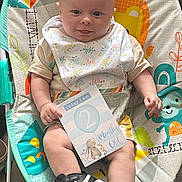 Damien joined the competition — help win amazing prizes! baby, infant, bouncer, bib, sign, shoe, nike, sneaker, colorful, pattern, monkey, smiling, tongue_out, cute, child, playful, clothing, indoor, person, seat