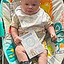 baby, infant, bouncer, bib, sign, shoe, nike, sneaker, colorful, pattern, monkey, smiling, tongue_out, cute, child, playful, clothing, indoor, person, seat