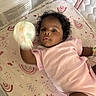 Malia is registered to the contest to win money with this photo: baby, infant, crib, mattress, pink_onesie, mittens, rainbow_pattern, sun_pattern, curly_hair, lying_down, child, indoor, soft_toys, pastel_colors, cotton_clothing, mesh_crib_sides, cute, person, baby_gesture, sleeping_area