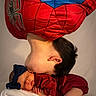 child, baby, sleeping_baby, spiderman_costume, red_clothing, blue_bow, headband, kiss, affection, family, portrait, cute, toddler, infant, soft_blanket, studio, love, bond, skin, hair