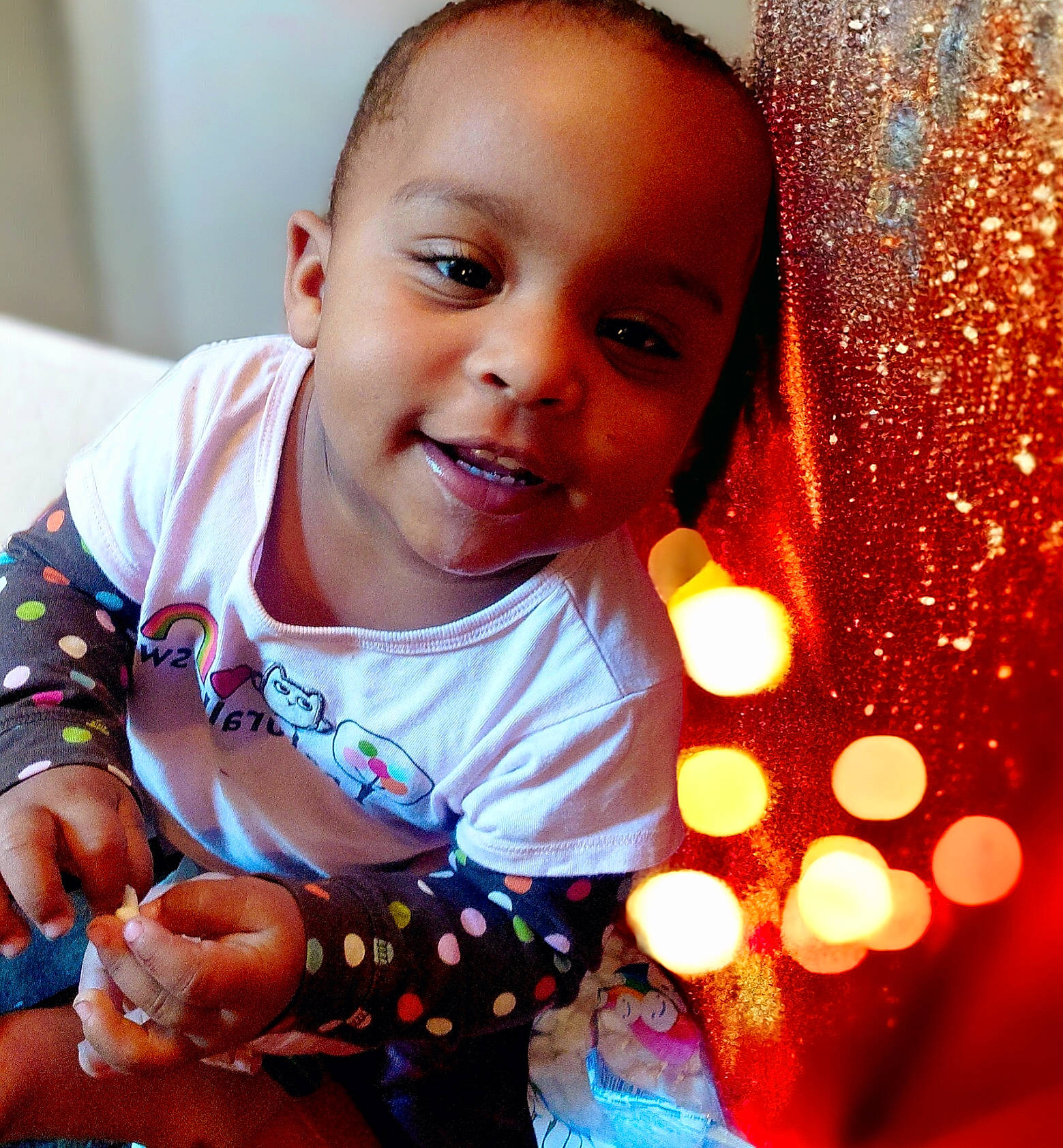 Leonna is registered to the contest to win money with this photo: baby, baby_toddler_clothing, cheek, dress, eye, face, facial_expression, finger, gesture, happy, head, human, iris, lip, nose, orange, person, skin, sleeve, smile