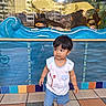 Mahbeer Rahman is registered to the contest to win money with this photo: aquarium, blue_shorts, casual_clothing, child, colorful_tiles, curious, fish, fish_tank, floor, indoor, plants, playful, portrait, reflection, shorts, sneakers, toddler, water, white_shirt, young_child