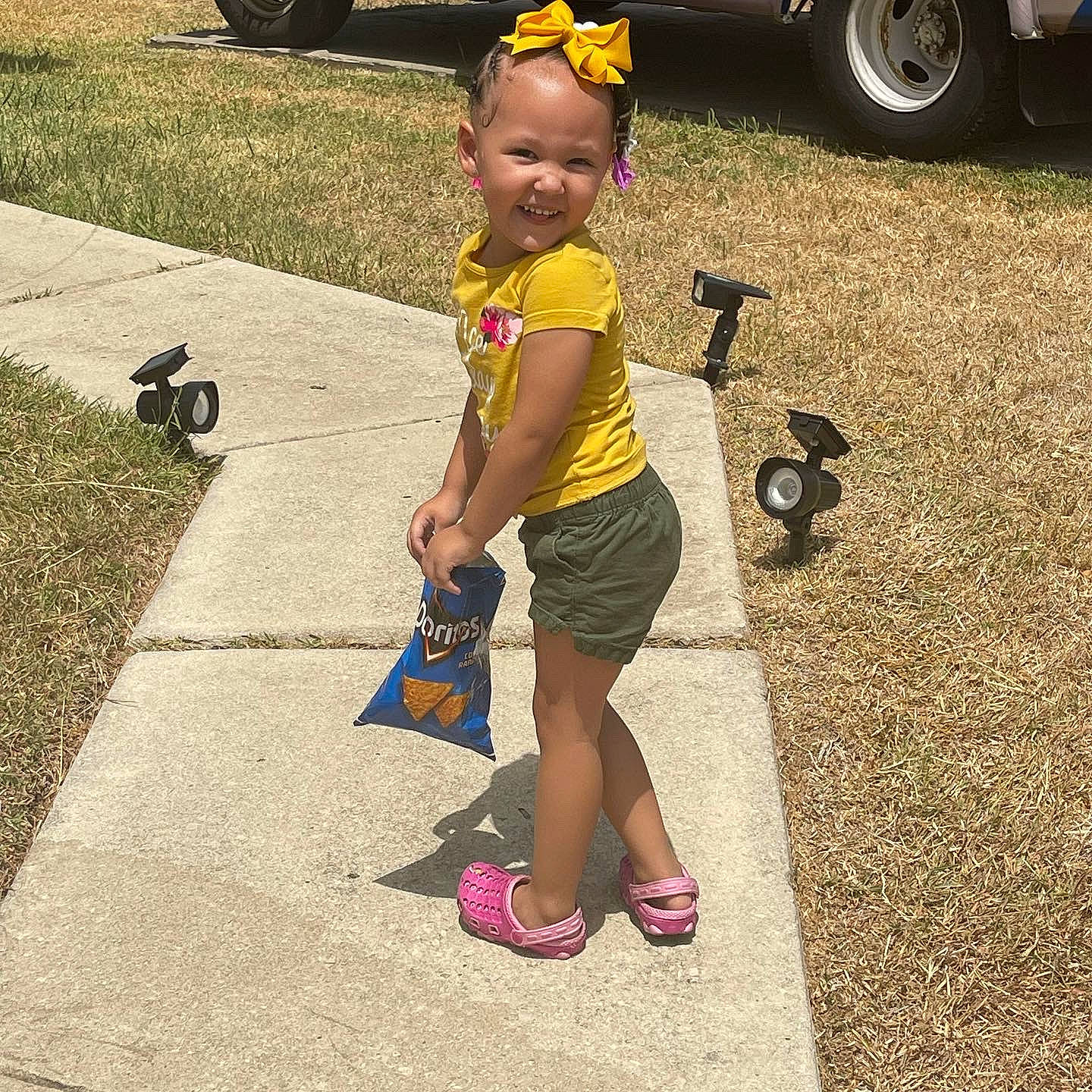 Zalay is registered to the contest to win money with this photo: asphalt, automotive_tire, baby, child, fun, grass, happy, human_leg, joy, person, recreation, road, road_surface, sandal, sidewalk, smile, tints_and_shades, tire, toddler, waist