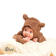Liam is registered to the contest to win money with this photo: baby, infant, costume, bear, brown, cute, milestone, three_months, blanket, soft, chewing, hand, portrait, child, fuzzy, lying_down, curious, wooden_sign, studio_photo, white_background