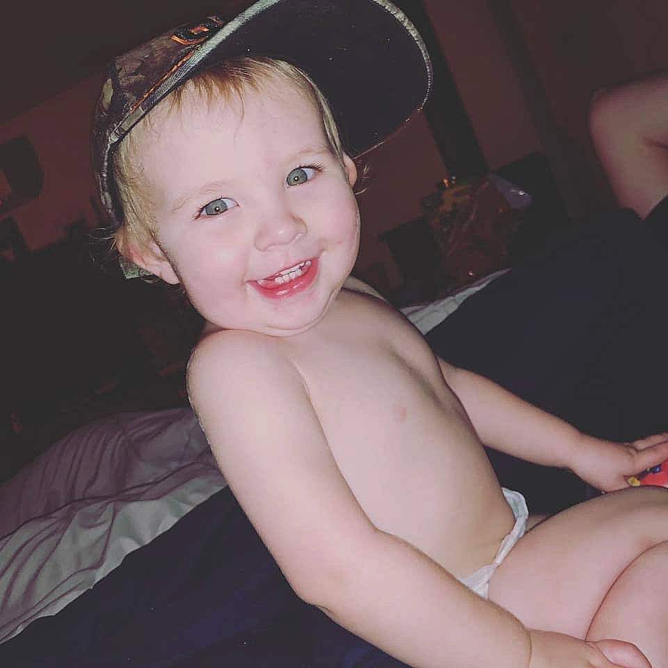 Thaddeus is registered to the contest to win money with this photo: arm, baby, beauty, cheek, child, child_model, ear, eye, face, facial_expression, hand, hat, head, headgear, joy, lip, organ, person, pink, skin