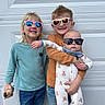 Jameson joined the competition — help win amazing prizes! child, baby, sunglasses, smile, standing, casual_clothing, jeans, plush_toy, garage_door, outdoor, siblings, long_hair, short_hair, holding, happy, portrait, cool, fashion, family, toddler