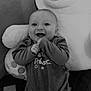 baby, smiling, pajamas, teddy_bear, plush_toy, couch, carpet, happy, infant, child, face, indoor, cute, cozy, soft, comfort, portrait, sitting, monochrome, black_and_white