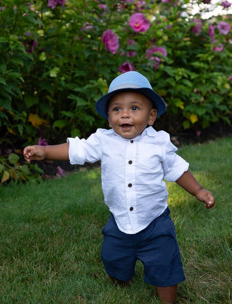 Oakland is registered to the contest to win money with this photo: baby, baby_toddler_clothing, child, flower, grass, headwear, lawn, person, pink, plant, play, sleeve, smile, toddler