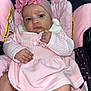 baby, infant, pink_clothing, headband, car_seat, child, person, cute, portrait, soft_texture, fabric, flower_accessory, indoors, comfort, seatbelt, skin, hand, face, expression, newborn
