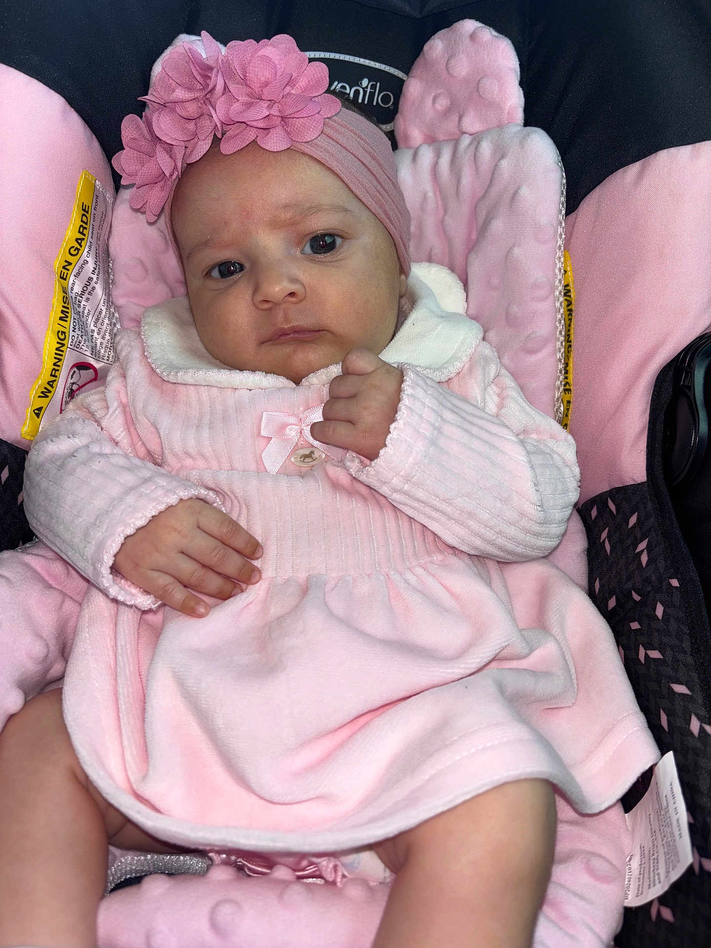 Adara Rose is registered to the contest to win money with this photo: baby, infant, pink_clothing, headband, car_seat, child, person, cute, portrait, soft_texture, fabric, flower_accessory, indoors, comfort, seatbelt, skin, hand, face, expression, newborn