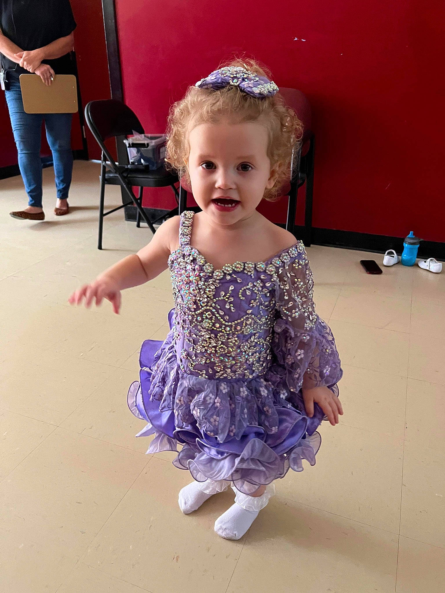 Marlena is registered to the contest to win money with this photo: baby_toddler_clothing, child, event, fashion_accessory, fashion_design, flooring, fun, happy, headpiece, iris, luggage_and_bags, magenta, pattern, person, purple, shorts, sitting, sleeve, smile, standing