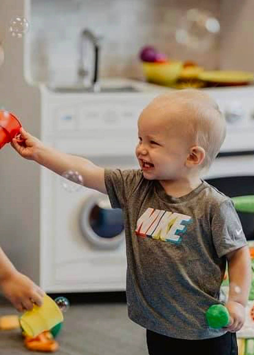Damon is registered to the contest to win money with this photo: baby, child, cooking, event, flooring, fun, gesture, green, happy, joint, kitchen, leisure, person, refrigerator, room, shoulder, smile, standing, t_shirt, toddler