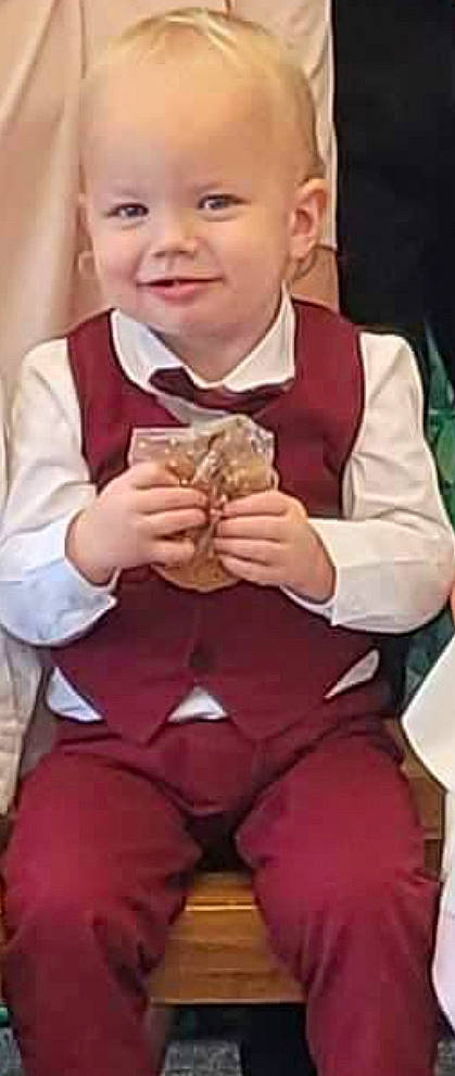 Damon is registered to the contest to win money with this photo: baby, child, comfort_food, cuisine, dish, finger, finger_food, food, formal_wear, gesture, human_body, joy, junk_food, person, sleeve, smile, tableware, thumb, tie, toddler