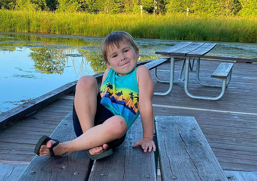 Elijah joined the competition — help win amazing prizes! bank, child, clothing, grass, hair, happy, joy, lake, leg, leisure, morning, outdoor_bench, outdoor_furniture, people_in_nature, person, plant, summer, thigh, tree, water
