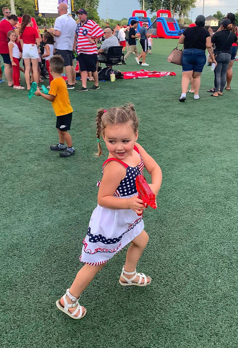 Thea joined the competition — help win amazing prizes! blurred, child, event, footwear, fun, grass, happy, headwear, joy, lap, lawn, leisure, person, recreation, red, shoe, shorts, sky, sneakers, style