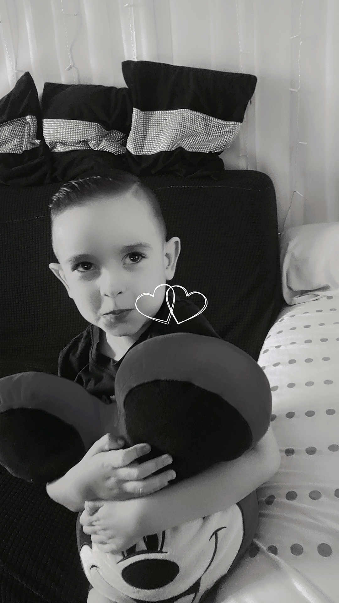 Rossé participe au concours pour gagner de l'argent avec cette photo : child, boy, plush_toy, mickey_mouse, couch, pillows, black_and_white, hugging, smiling, indoors, cute, decor, portrait, face, hands, toy, childhood, cozy, seated, expression