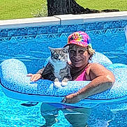 Tommy Boy joined the competition — help win amazing prizes! animal, blue, cat, colorful_cap, floating, inflatable_ring, leisure, outdoor, pattern, person, pet, pool, relaxation, smiling, summer, sunny, swimming, tabby_cat, vacation, water