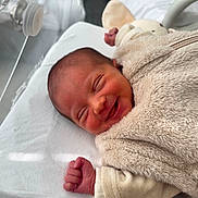 Arya a rejoint le concours — aidez-le/la à gagner de superbes lots ! newborn, baby, smile, hospital, incubator, bassinet, cozy, blanket, toy, infant, sleepwear, bed, cute, child, soft_toy, healthcare, resting, tiny_hand, wrapped, happy