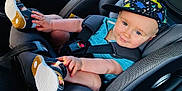 Ethan a rejoint le concours — aidez-le/la à gagner de superbes lots ! toddler, child, car_seat, blue_shirt, sandals, hat, dinosaur_pattern, car_interior, seatbelt, smile, baby, sunlight, playful, sitting, comfort, window, face, footwear, hand, casual