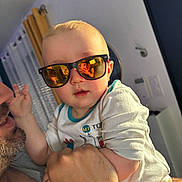 Ethan participe au concours pour gagner de l'argent avec cette photo : baby, child, sunglasses, reflection, person, adult, indoor, curtains, wall, intercom, hand, clothing, portrait, face, holding, casual, light, smile, selfie, cool