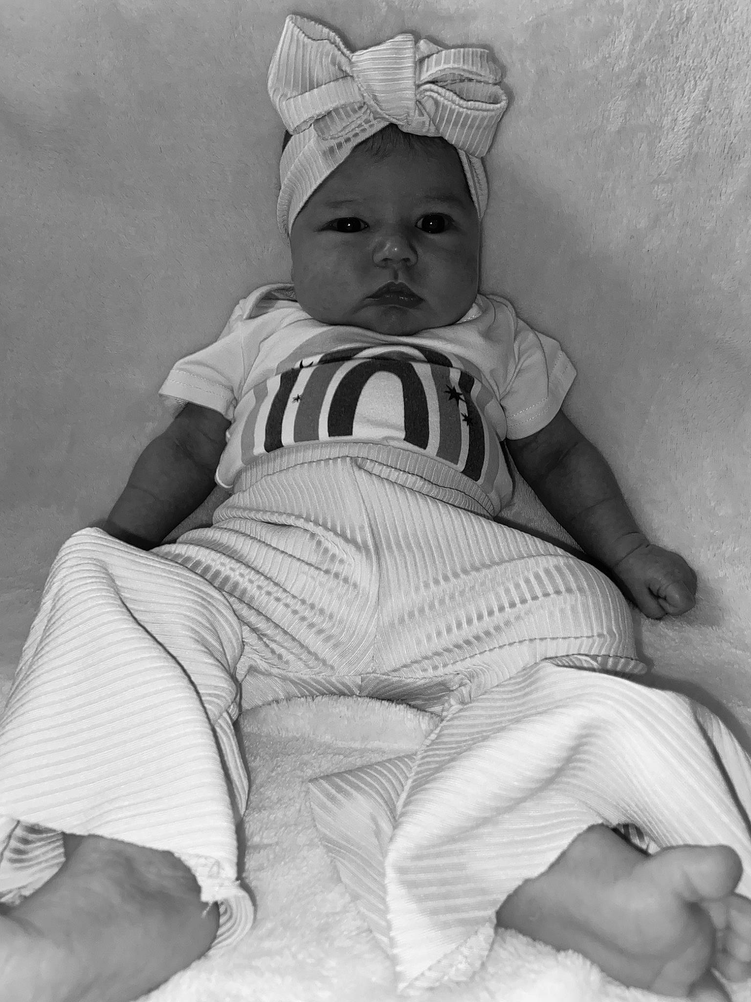 Ella Mae is registered to the contest to win money with this photo: baby, baby_toddler_clothing, cap, child, comfort, hand, hat, headwear, human_leg, knee, leg, monochrome, monochrome_photography, person, photograph, sitting, skin, smile, style, thigh