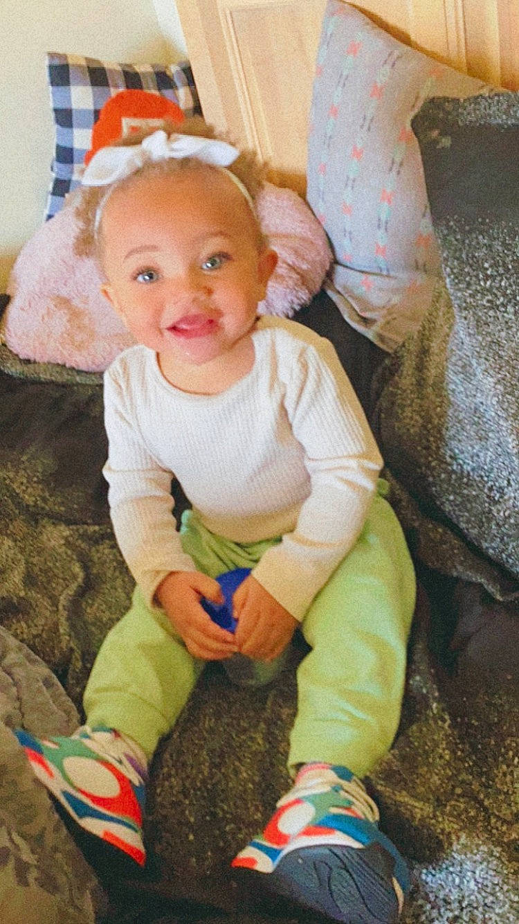 Adira is registered to the contest to win money with this photo: baby, baby_toddler_clothing, cheek, child, comfort, eye, face, facial_expression, flooring, fun, happy, head, iris, person, pink, sitting, skin, sleeve, smile, sock