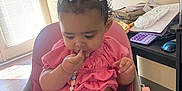 Nevayla joined the competition — help win amazing prizes! baby, child, high_chair, pink, bow, snack, bowl, food, indoor, table, clothing, person, cute, curly_hair, earrings, beads, furniture, window, light, floor
