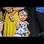 toddler, child, smile, blue_and_white, headband, floral_pattern, finger_gesture, curly_hair, dress, person, people, yellow_dress, pink_sandals, adult, group, indoor, happy, cute, fashion, portrait