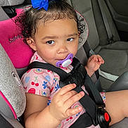 Nevayla is registered to the contest to win money with this photo: toddler, child, car_seat, pacifier, blue_bow, curly_hair, pink_clothing, car_interior, seat_belt, safety, cute, portrait, baby, young_child, seat, strapped_in, hand, expression, travel, vehicle