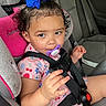 toddler, child, car_seat, pacifier, blue_bow, curly_hair, pink_clothing, car_interior, seat_belt, safety, cute, portrait, baby, young_child, seat, strapped_in, hand, expression, travel, vehicle