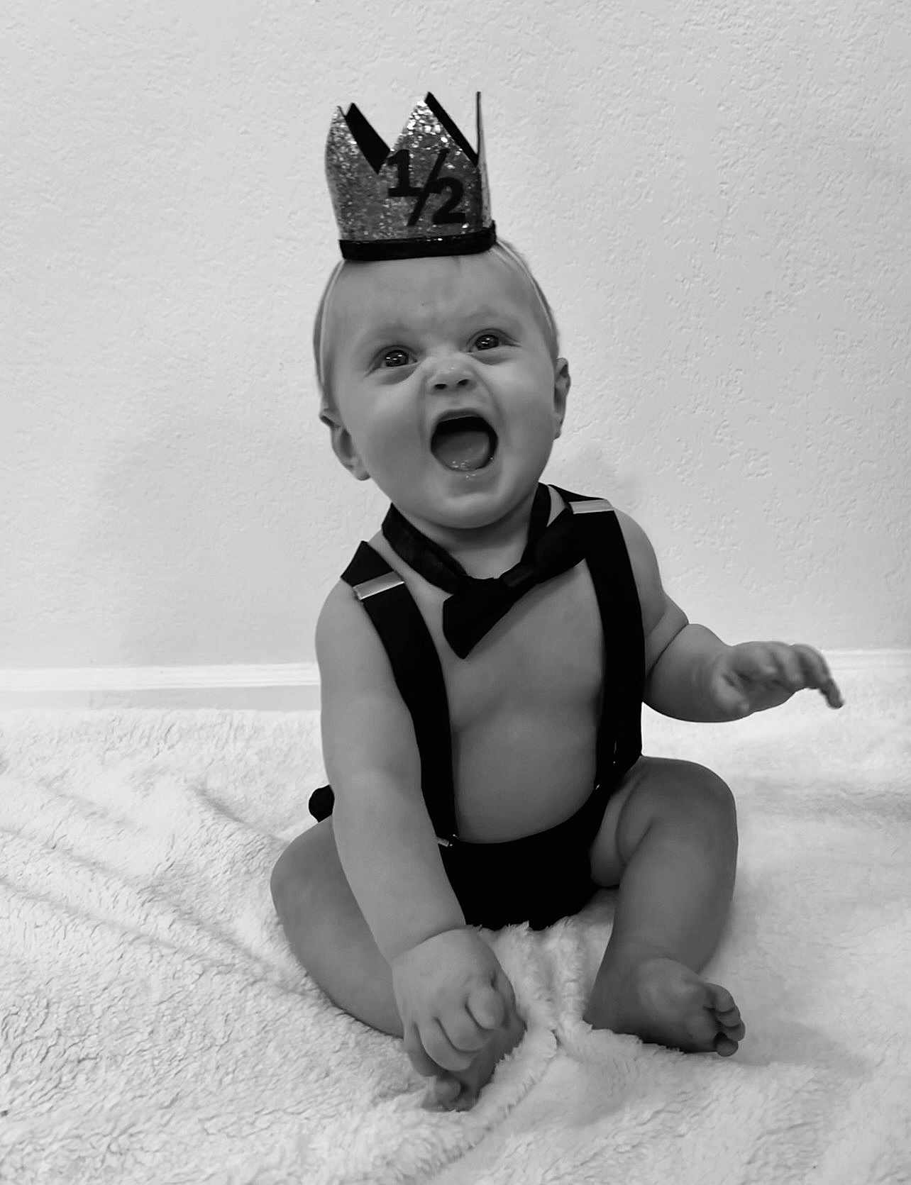 Jett joined the competition — help win amazing prizes! baby, crown, bow_tie, suspenders, black_and_white, smiling, happy, infant, sitting, blanket, cute, portrait, child, one_half, celebration, indoor, expression, toddler, clothing, face