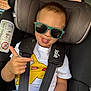 child, toddler, car_seat, sunglasses, tongue_out, pointing, shirt, pikachu, seatbelt, joie_brand, car_interior, window, hair, casual_clothing, playful, person, seat, fun, young_child, safety