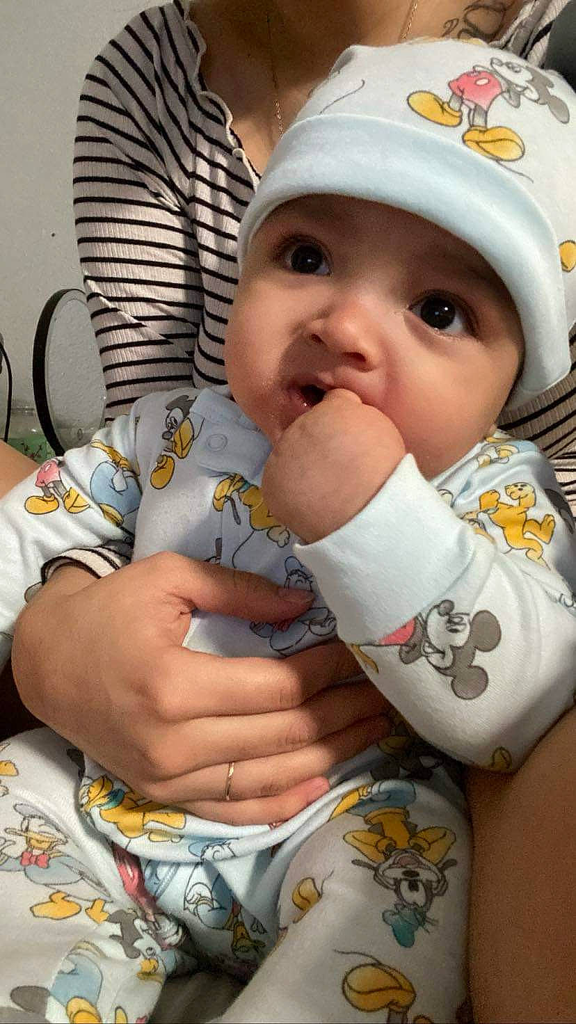 Daniel is registered to the contest to win money with this photo: baby, baby_products, baby_toddler_clothing, bib, cap, cheek, child, chin, eye, face, facial_expression, happy, headwear, lip, mouth, nail, nose, person, sitting, skin