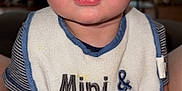 Karson joined the competition — help win amazing prizes! baby, infant, bib, blue_eyes, chubby, cute, expression, face, hands, feet, indoor, person, portrait, skin, sitting, striped_shirt, text_on_bib, young_child, wide_eyes, close_up