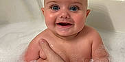 Karson is registered to the contest to win money with this photo: baby, bath, bubbles, foam, smiling, child, water, skin, arm, hand, bathtub, tiled_wall, happy, cute, infant, person, indoor, plaster, wet, head
