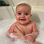 Karson is registered to the contest to win money with this photo: baby, bath, bubbles, foam, smiling, child, water, skin, arm, hand, bathtub, tiled_wall, happy, cute, infant, person, indoor, plaster, wet, head