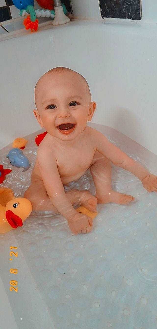 Mayron participe au concours pour gagner de l'argent avec cette photo : baby, baby_bathing, baby_playing_with_toys, bathing, bathroom, bathtub, cheek, eye, finger, fluid, fun, happy, head, iris, joy, mouth, person, skin, smile, toddler