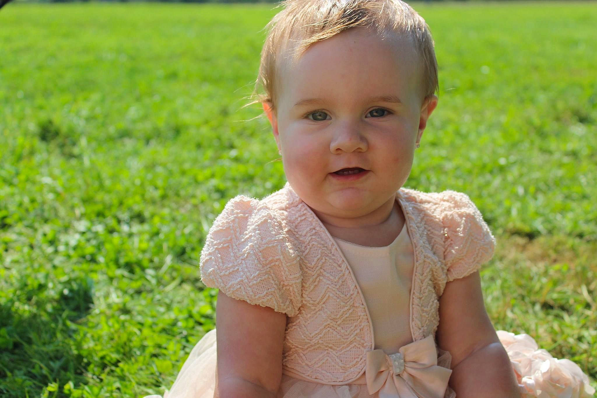 Ainsley is registered to the contest to win money with this photo: baby, baby_toddler_clothing, cheek, dress, eye, face, grass, hair, happy, head, iris, leaf, meadow, morning, people_in_nature, person, plant, skin, smile, summer