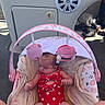 Ellie is registered to the contest to win money with this photo: baby, infant, swimsuit, red, polka_dot, baby_seat, toy, blanket, boat, deck, sunlight, legs, pink, cushion, relaxing, child, summer, outdoor, cute, peaceful