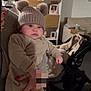 baby, infant, beanie, pompom_hat, knit_hat, onesie, beige_clothing, hand, red_nails, stroller, pram, mirror, reflection, living_room, couch, shelf, photo_frame, blanket, serious_face, portrait