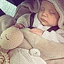 baby, infant, sleeping, closed_eyes, car_seat, seat_belt, blanket, knitted_hat, hood, knit_sweater, soft_toy, knit_toy, hand, cozy, neutral_tones, portrait, newborn, cute, car_interior, peaceful