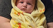 Adam joined the competition — help win amazing prizes! baby, infant, child, caregiver, portrait, indoors, blanket, yellow_blanket, hooded_blanket, sitting, held, face, smiling, eyes, hands, family, home, television, photography, safe